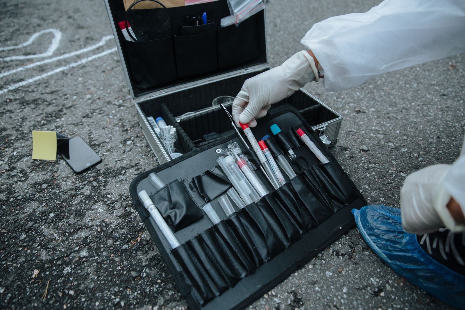 An investigator collecting evidence at a scene, the casing on the same chain of custody